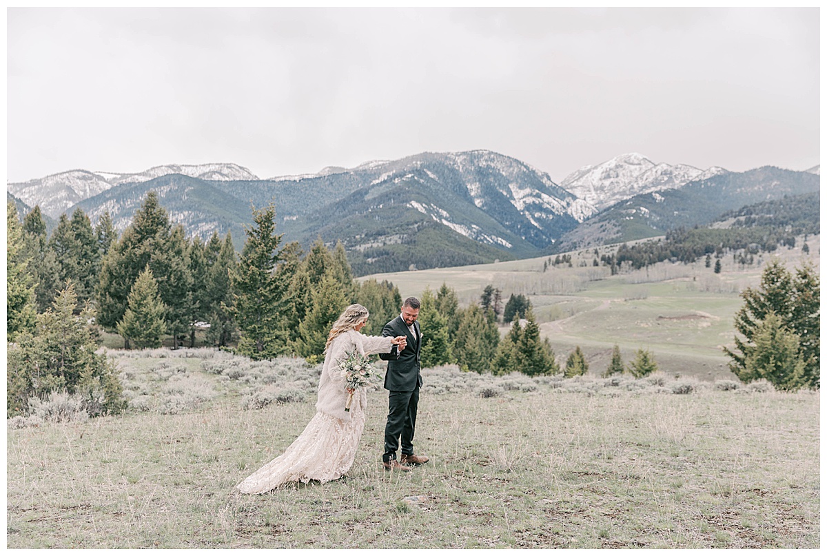 Groom helping bride during wedding portraits in Gardiner montana.